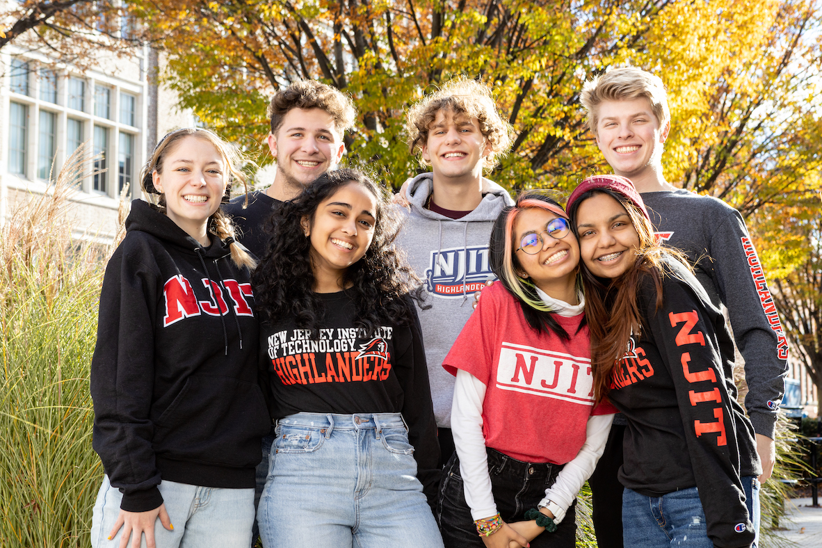 Group of diverse students smiling on campus in front of trees