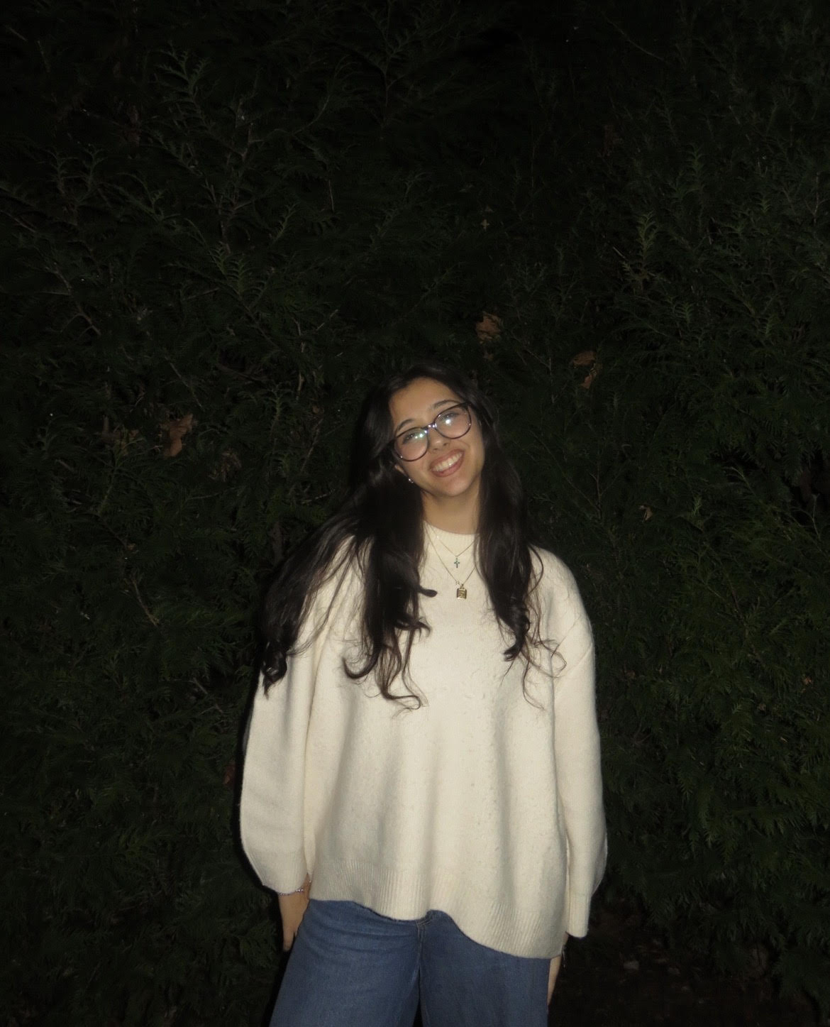 A woman in a white sweater with long brown hair.